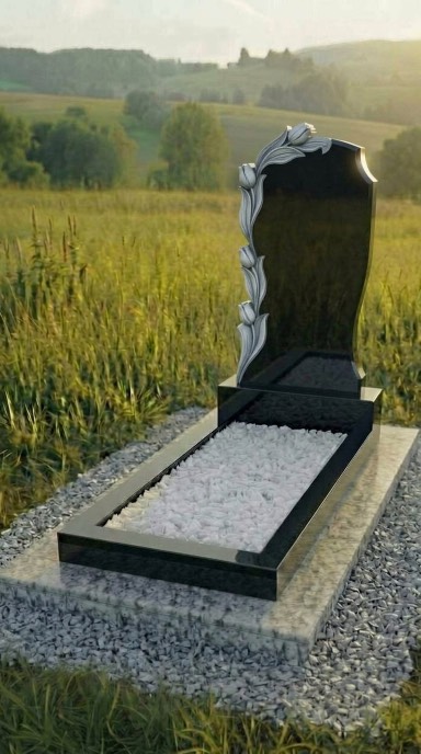 Вертикальный памятник из карельского гранита с плавным силуэтом и декоративными цветами по левому краю