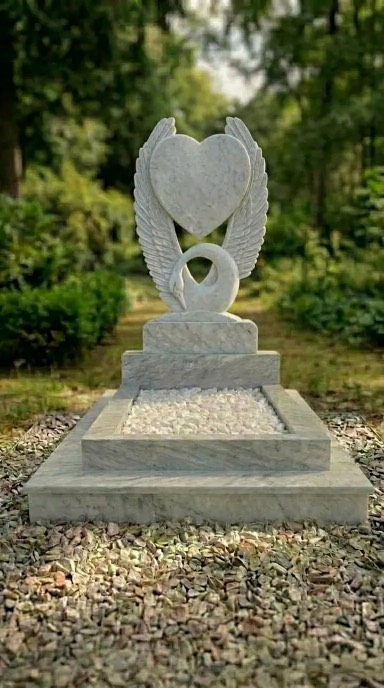 Памятник из мрамора Полевской с резной стелой в виде сердца и лебедя, цветной фотокерамикой и благоустройством могилы